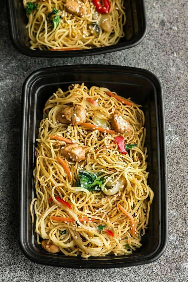 Top view of chicken chow mein in a black meal prep lunch container