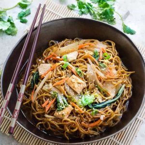 A serving of Chicken Chow Mein in a brown bowl with chopsticks