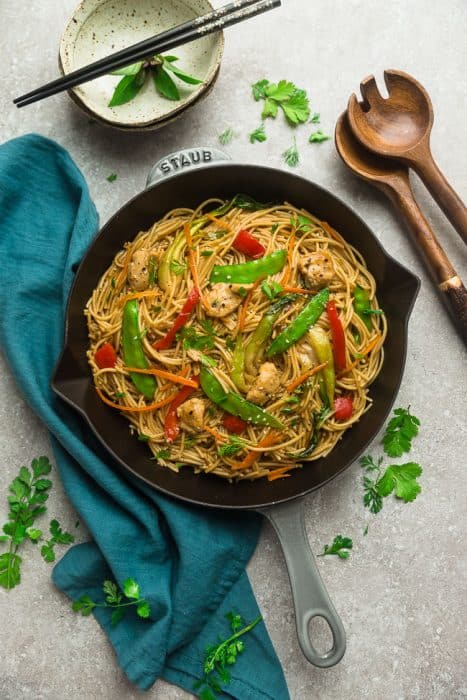 Easy Chicken Lo Mein noodles recipe in a large cooking skillet with beautiful chopsticks for a perfect meal.
