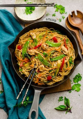 Easy Chicken Lo Mein noodles recipe in a large cooking skillet with beautiful chopsticks for a perfect meal.