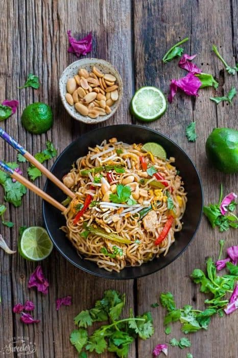 Top view of chicken pad thai in a bowl with chopsticks