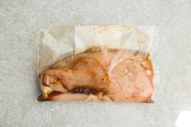 A Raw Chicken Breast Marinating in a Resealable Plastic Bag