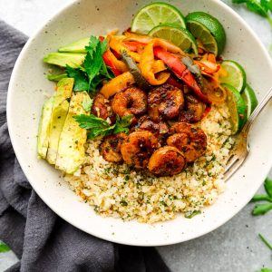 Chili Lime Shrimp Fajita Bowls are the perfect healthy meal for spring or summer. Best of all, they're low carb, paleo, whole 30, keto-friendly and easy to customize and made with cauliflower rice, bell peppers and avocado.