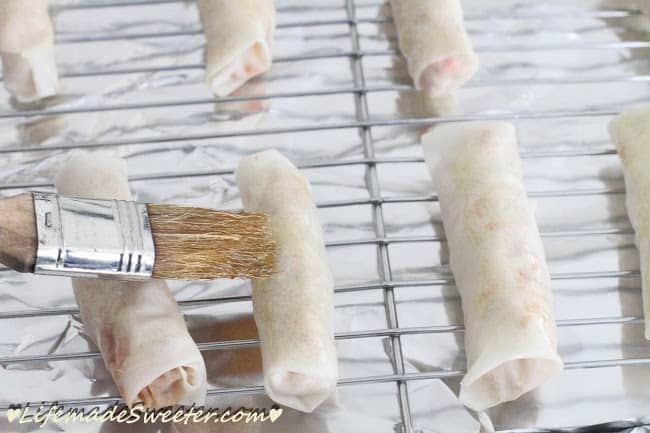 Chinese spring rolls being brushed with a small amount of oil