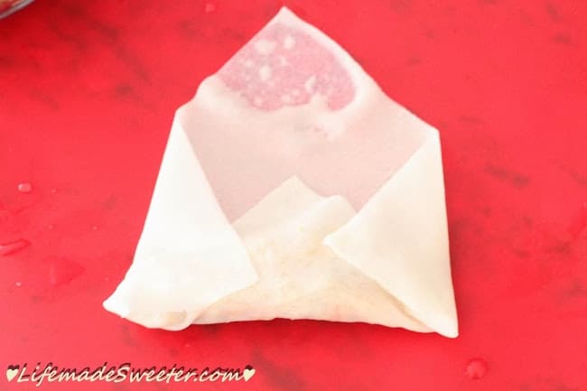 Egg roll filling inside of a spring roll wrapper with the end and sides folded up