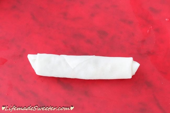 An uncooked Chinese spring roll right after it has been wrapped and sealed