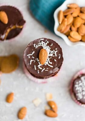 Top view of Chocolate Fat Bombs on a grey background with almonds and shredded coconut