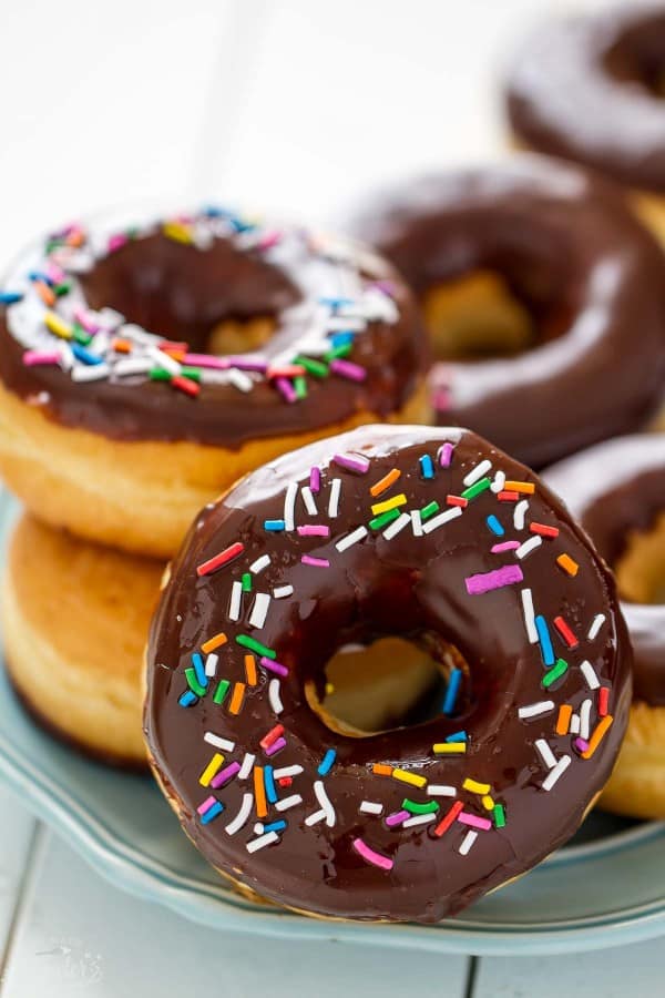 Chocolate Frosted Donuts with Sprinkles piled on a plate