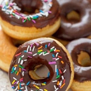 Chocolate Frosted Donuts with Sprinkles piled on a plate