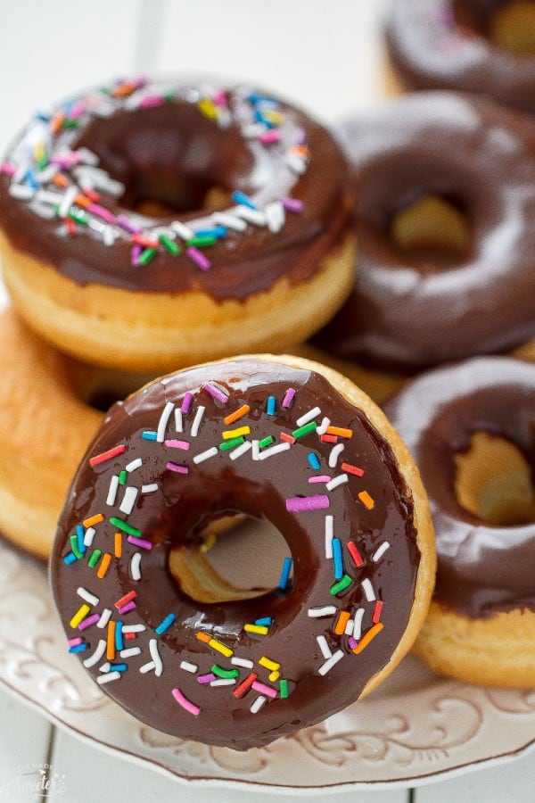 Chocolate Frosted Donuts with Sprinkles piled on a plate