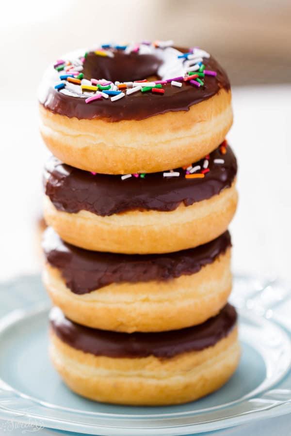 Chocolate Frosted Donuts with Sprinkles stacked on a plate