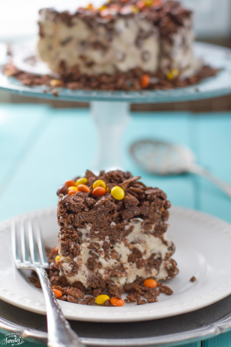 A slice of chocolate peanut butter chocolate ice cream cake on a white plate with silver fork.