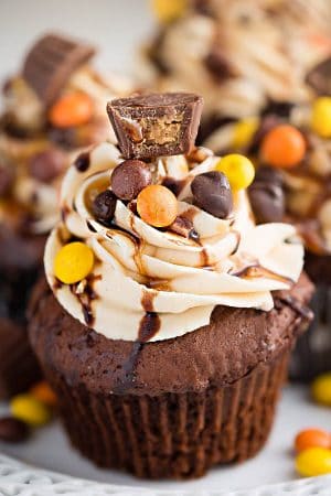 Close-up of a Peanut Butter Chocolate Cupcake topped with peanut butter frosting, Reese's pieces, a mini Reese's peanut butter cup