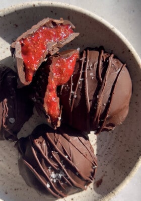 Five chocolate strawberry bites with two cut into halves in a white bowl