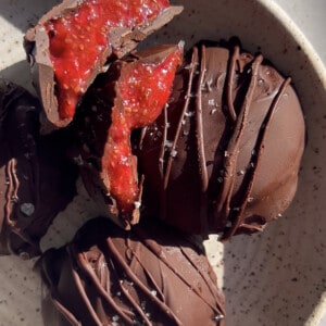 Five chocolate strawberry bites with two cut into halves in a white bowl