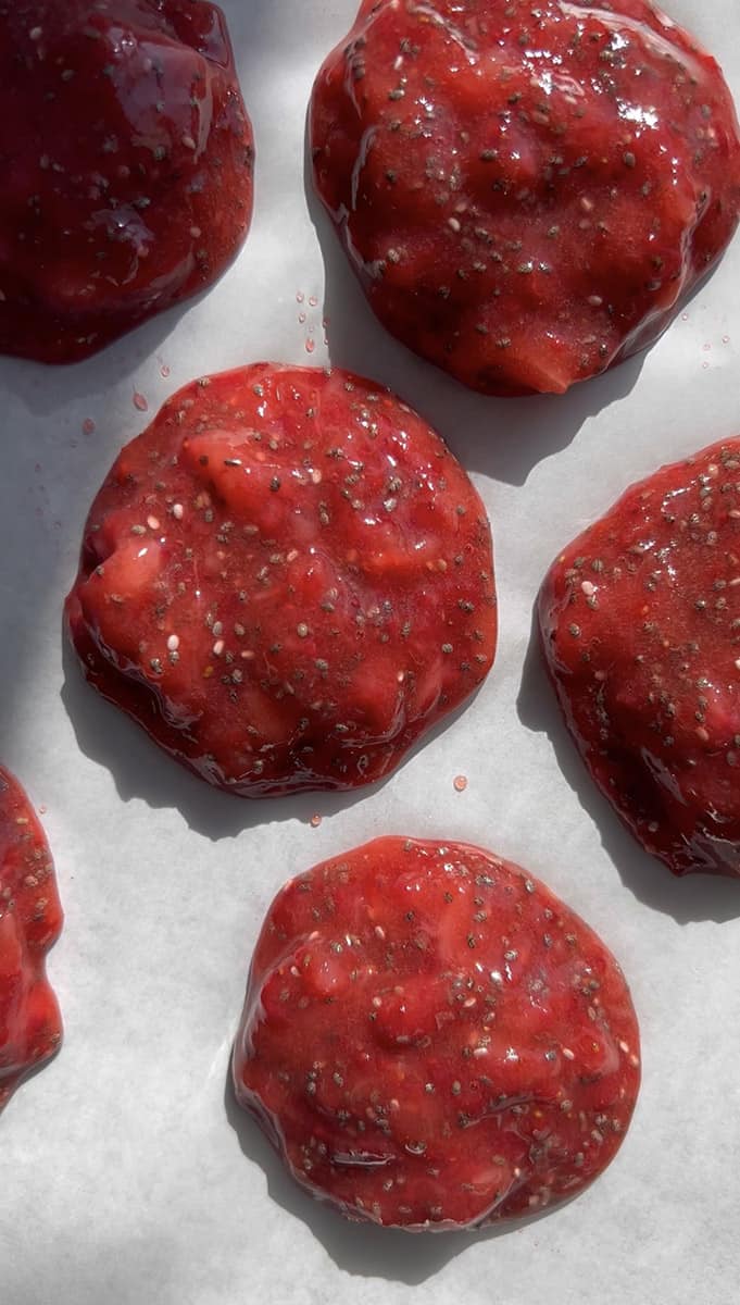 Six strawberry jam bites on a parchment-lined baking sheet