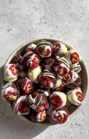 A pile of chocolate stuffed raspberries in a bowl .