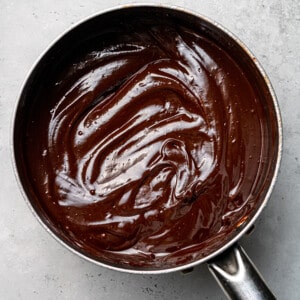 Overhead view of melted chocolate in a stainless steel pot
