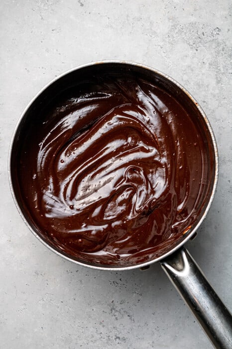 Overhead view of melted chocolate in a stainless steel pot