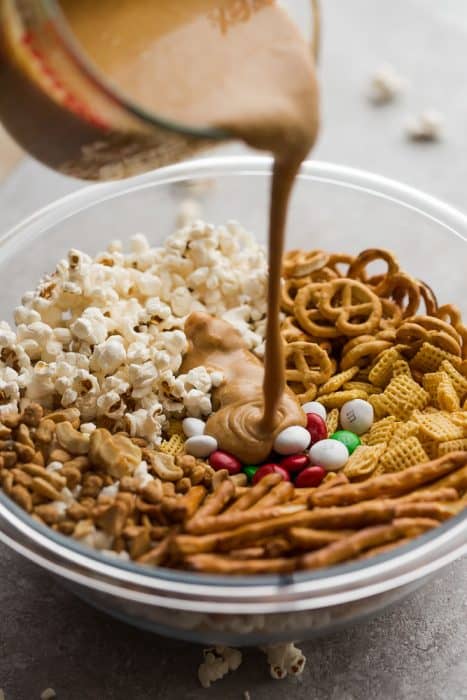 Top view of ingredients in a clear bowl to make holiday snack mix