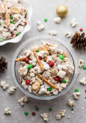 Reindeer Munch - the perfect easy sweet and salty snack to munch on at holiday parties or while watching Christmas movies. Best of all, this simple mix is fun to make with popcorn, Rice Chex cereal, cashews, peanut butter, pretzels and festive M&M's.