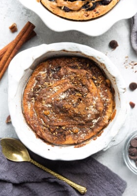 Churro Vegan Baked Oatmeal in a White Ramekin Next to a Spoon and Kitchen Cloth