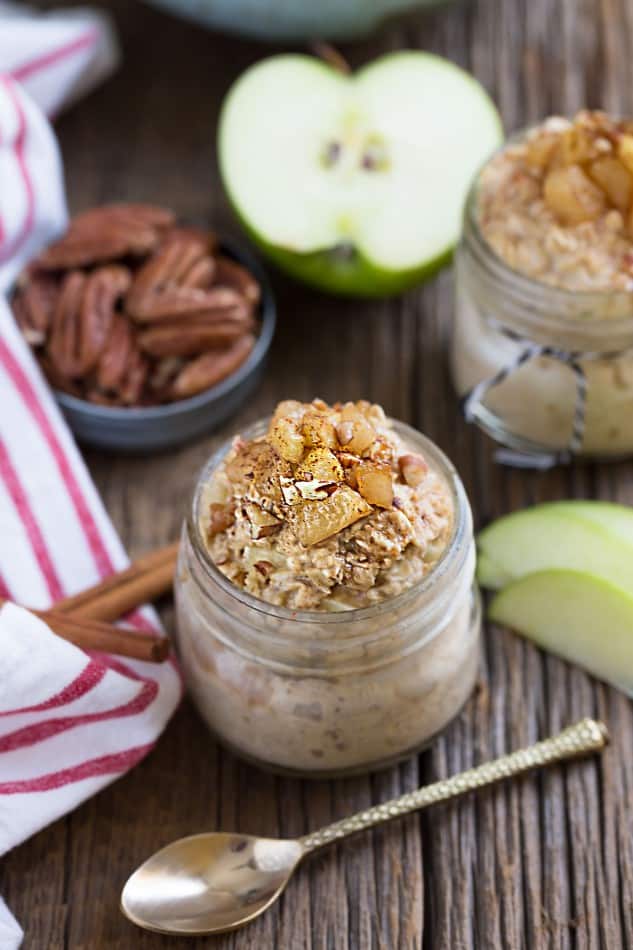 Two jars of Cinnamon Apple Pie Overnight Oats surrounded with ingredients