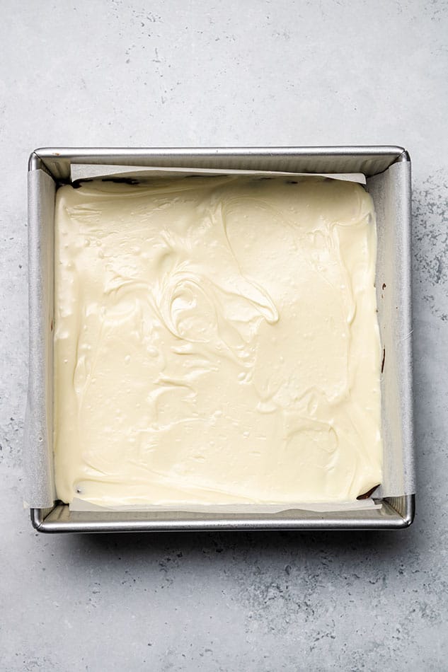 Overhead view of melted white chocolate in a square pan