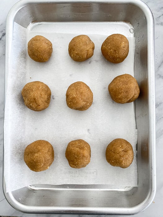 Top view of cookie dough balls on a parchment lined baking sheet