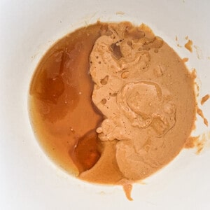Top view of maple syrup and cashew butter in a white bowl