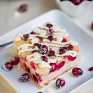 Top view of a square of cranberry cake on a white square plate