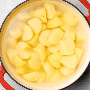 Peeled and cut Yukon Gold potatoes inside of a pot filled with water