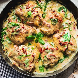 6 Chicken Thighs simmered in a creamy sun-dried tomato sauce in a large skillet