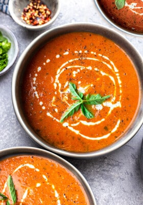 Top view of one bowl of Whole30 tomato soup on a grey background