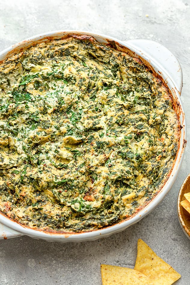 45 degree shot of a vegan Spinach Dip in a white round baking dish