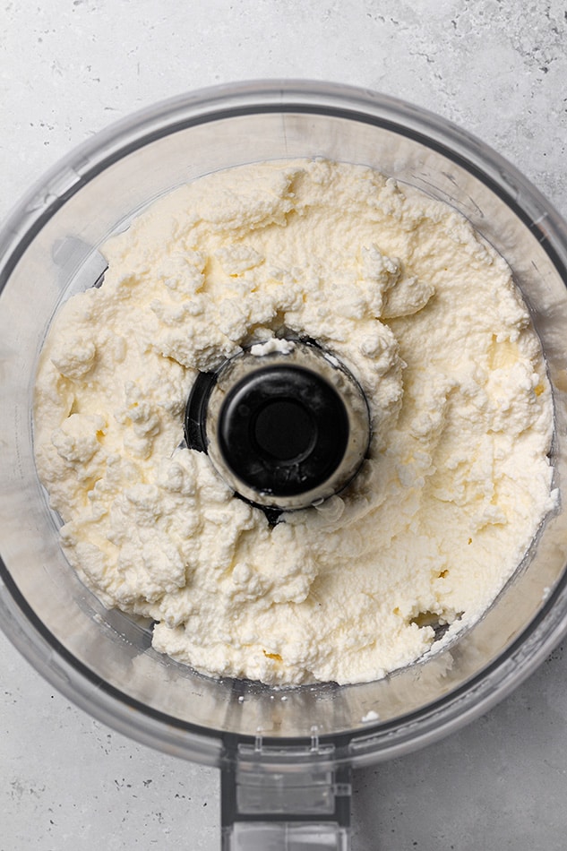 Dairy-free ricotta cheese in a food processor sitting on a kitchen countertop