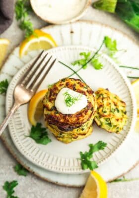 The bird's-eye view of a plate holding a stack of six zucchini fritters