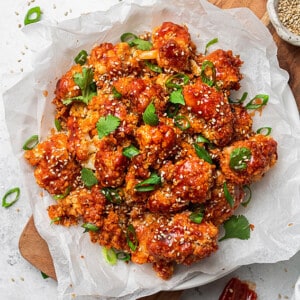 Overehead view of a batch of cripsy cauliflower wings in a white bowl