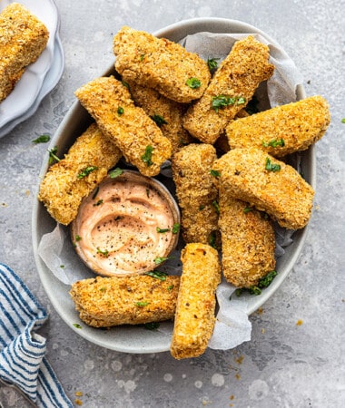 A pile of tofu fries in a an oval dish with creamy spicy dip