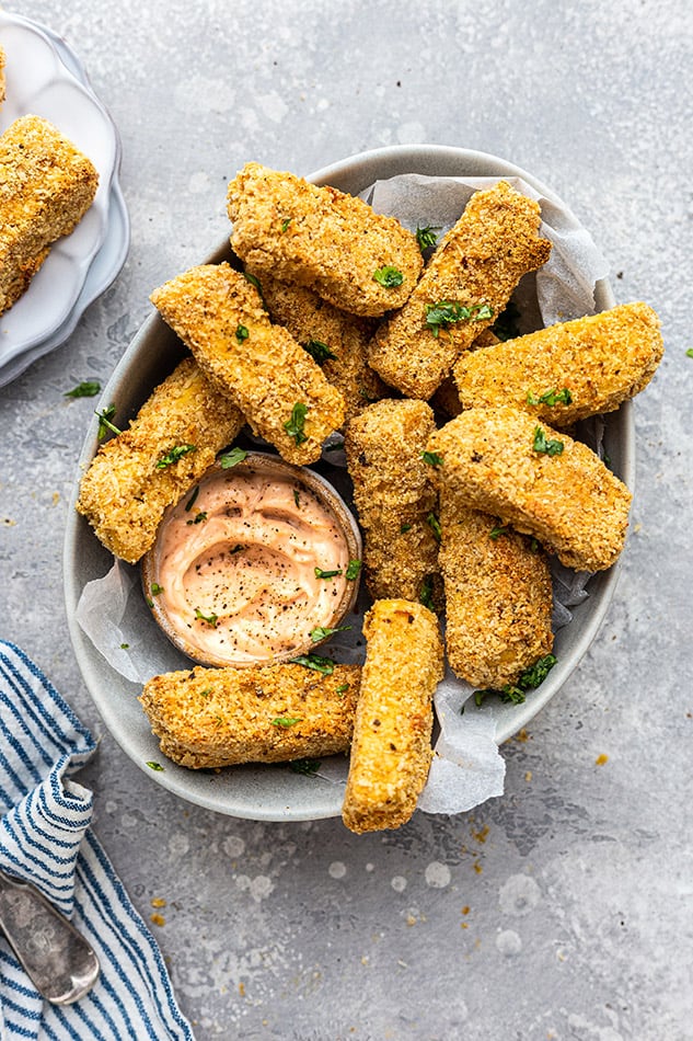 Overhead view of Tofu Tenders with dipping sauce in a paper-lined bowl