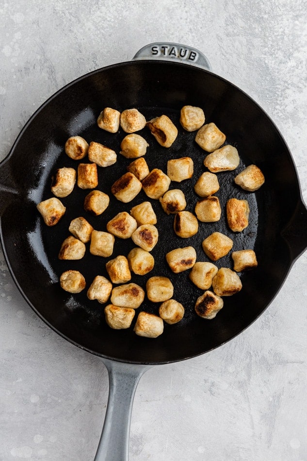 Overhead view of gnocchi getting browned in a skillet