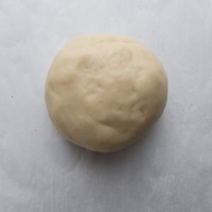 Top view of raw sugar cookie dough ball on parchment paper