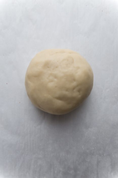 Top view of raw sugar cookie dough ball on parchment paper