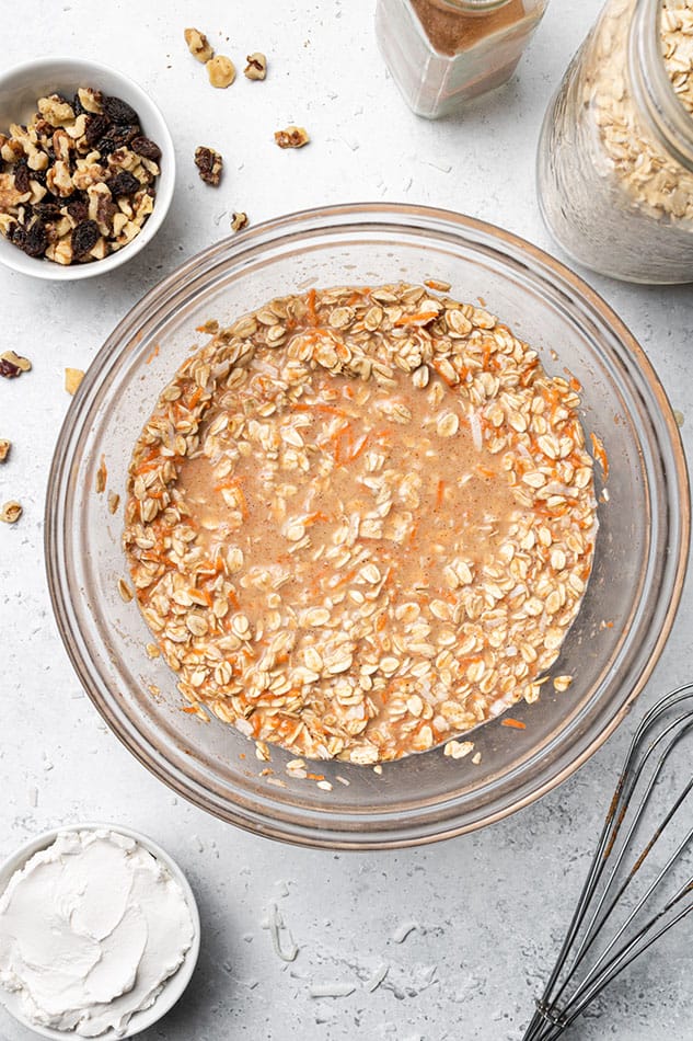 Carrot cake baked oatmeal batter in a glass mixing bowl on a kitchen countertop