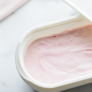 Top view of blended healthy strawberry ice cream in an ice cream container