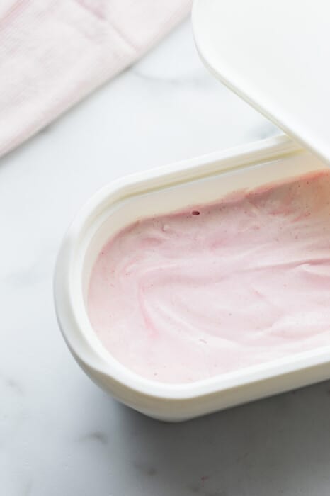 Top view of blended healthy strawberry ice cream in an ice cream container