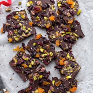 Overhead view of pieces of dark chocolate bark with pistachios and dried fruit