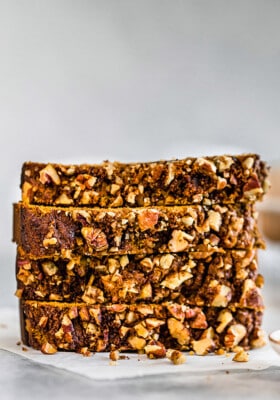 Side view of four slices of healthy pumpkin bread on a white background