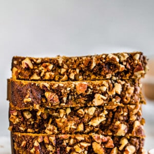 Side view of four slices of healthy pumpkin bread on a white background