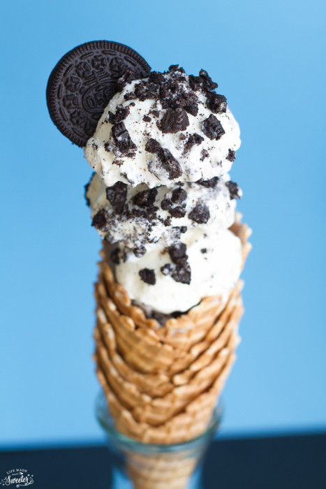 No Churn Cookies and Cream Oreo Ice cream scooped into a stack of waffle cones and topped with an oreo